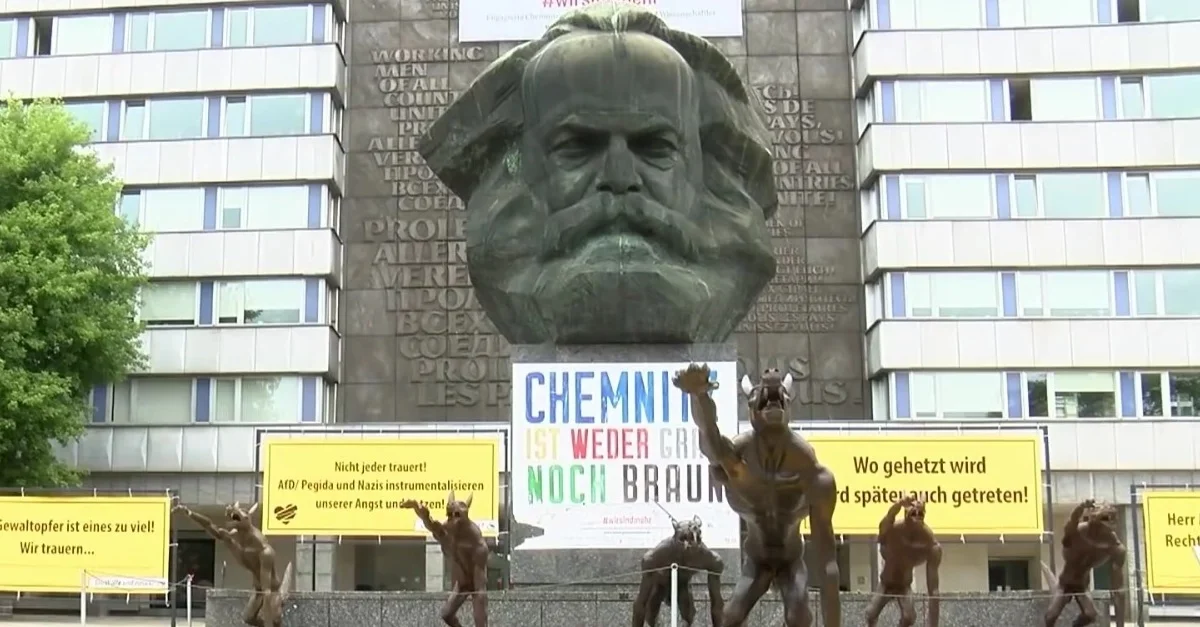 Bild: „Kunstaktion gegen Hass“ – Hitlergruß-zeigende Wölfe vor Marx-Kopf in Chemnitz aufgestellt / Screenshot YouTube @ 02:47 min