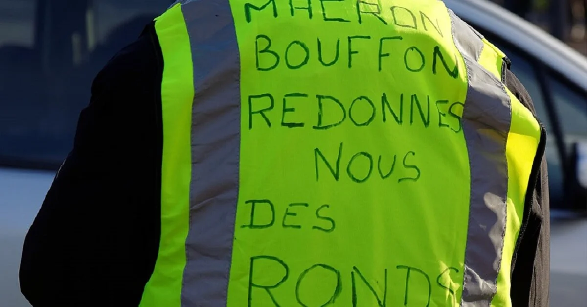 Die gelben Westen wurden zum Symbol des Widerstands gegen die französische Regierung. Übersetzung der Aufschrift (sinngemäß): „Macron, du Kasperl, gib uns unsere Kohle zurück!“. Symbolbild: Thomas Bresson via Wikimedia Commons [CC BY 4.0 (Bild zugeschnitten).