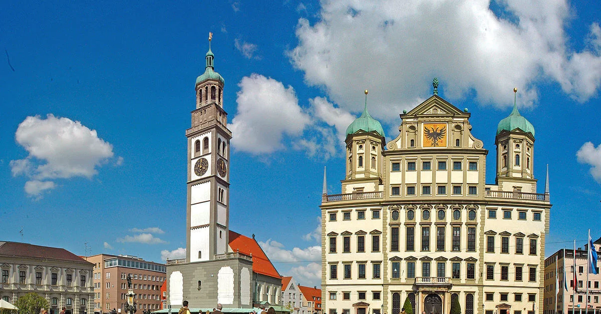 Bild: Rathausplatz in Augsburg / Guido Radig [CC BY 3.0], von Wikimedia Commons (Bild zugeschnitten)
