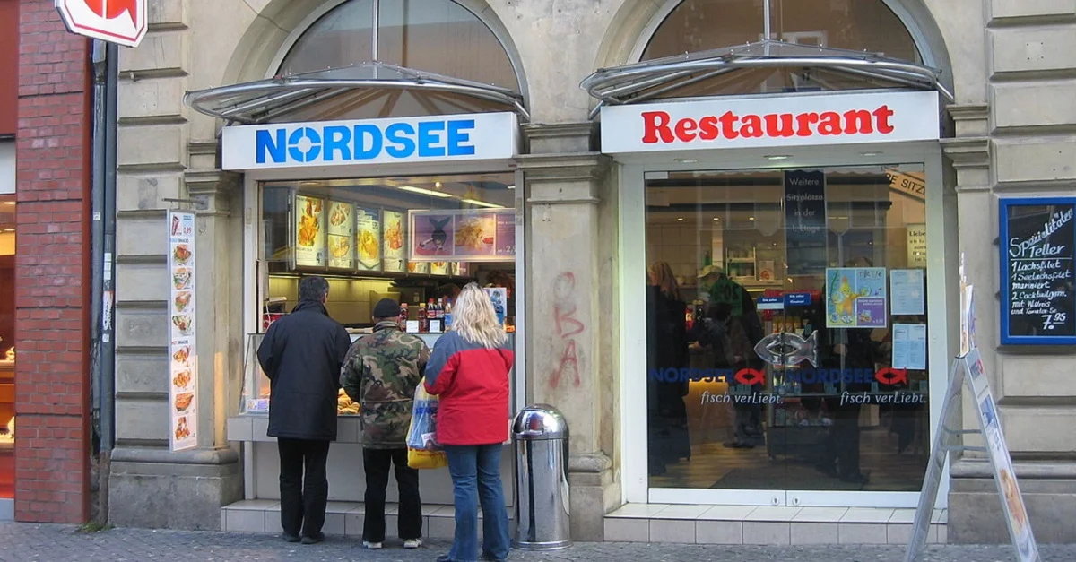 Drei &#8222;Dieters&#8220;, wie sie sich die kurdisch-stämmige Journalistin Mely Kiyak vorstellt, stellen sich für ein lecker Fischbrötchen an. Symbolbild (Nordsee-Restaurant in Braunschweig): Vic Fontaine via Wikimedia Commons [CC BY-SA 3.0] (Bild zugeschnitten)

