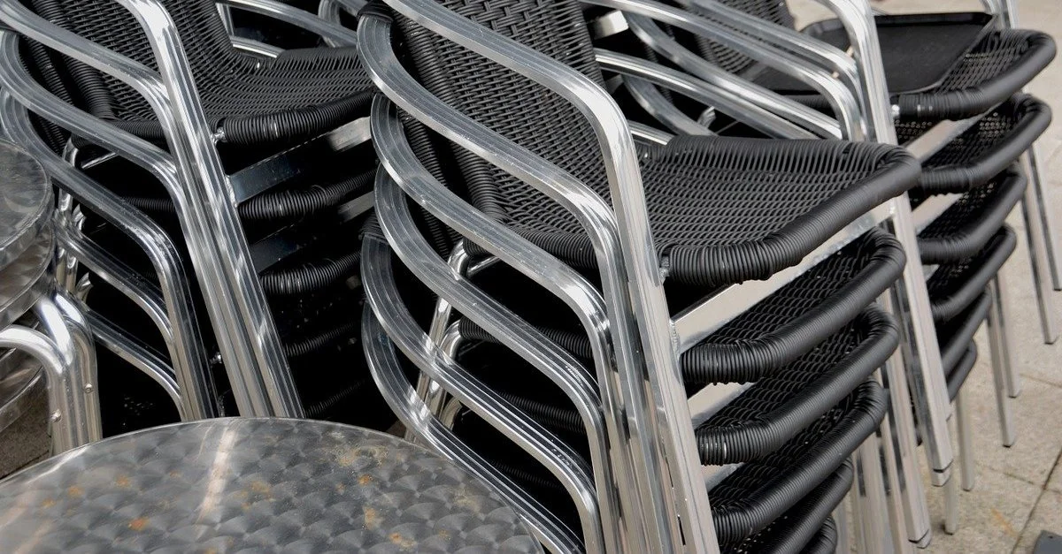 Symbolbild: Getapelte Stühle vor einem geschlossenen Café / Bild: Bild von Dean Moriarty auf Pixabay (Bild zugeschnitten)