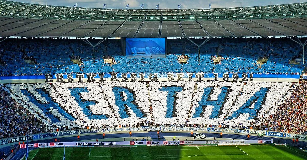 Bild: Hertha BSC-Fans bei einem Spiel im Berliner Olympiastadion / Bild: Frankinho from Berlin, Germany, CC BY 2.0, via Wikimedia Commons (Bild zugeschnitten)