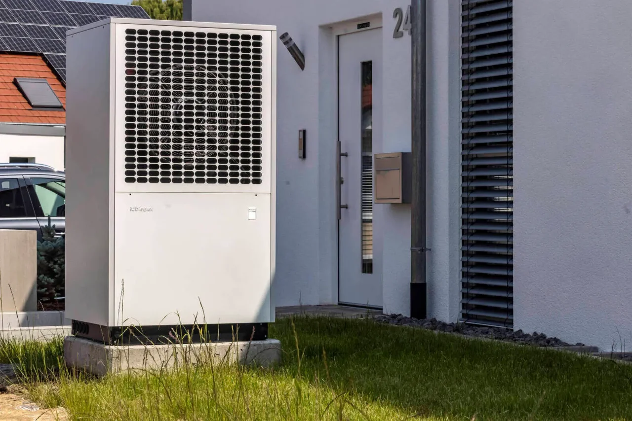 Eine Wärmepumpe im Garten eines Einfamilienhauses