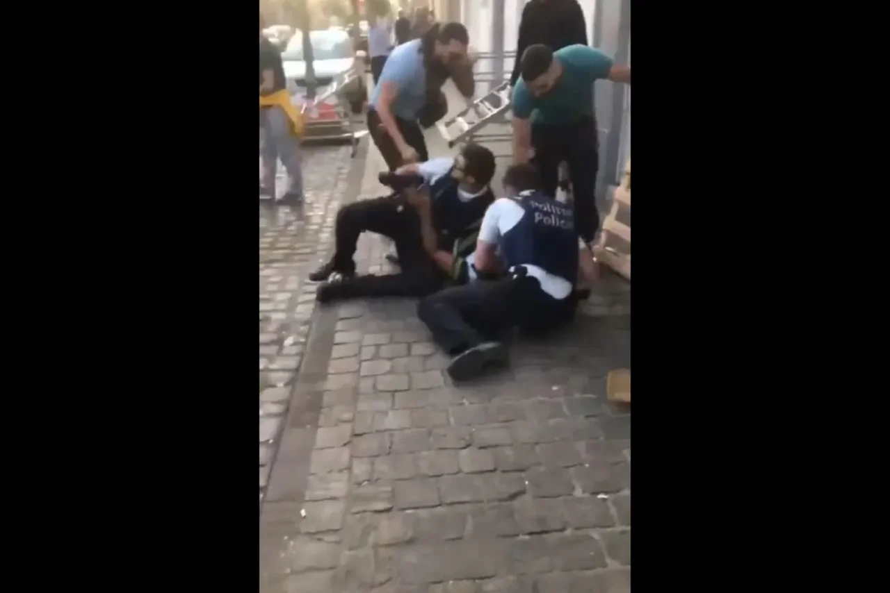 Zwei Polizeibeamte werden bei der Festnahme eines Verdächtigen von Umstehenden angegriffen.